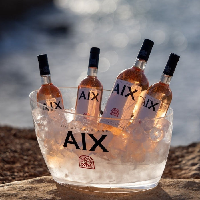 Maison Saint AIX rosé bottles in large and small formats displayed in an ice budcket by the sea.