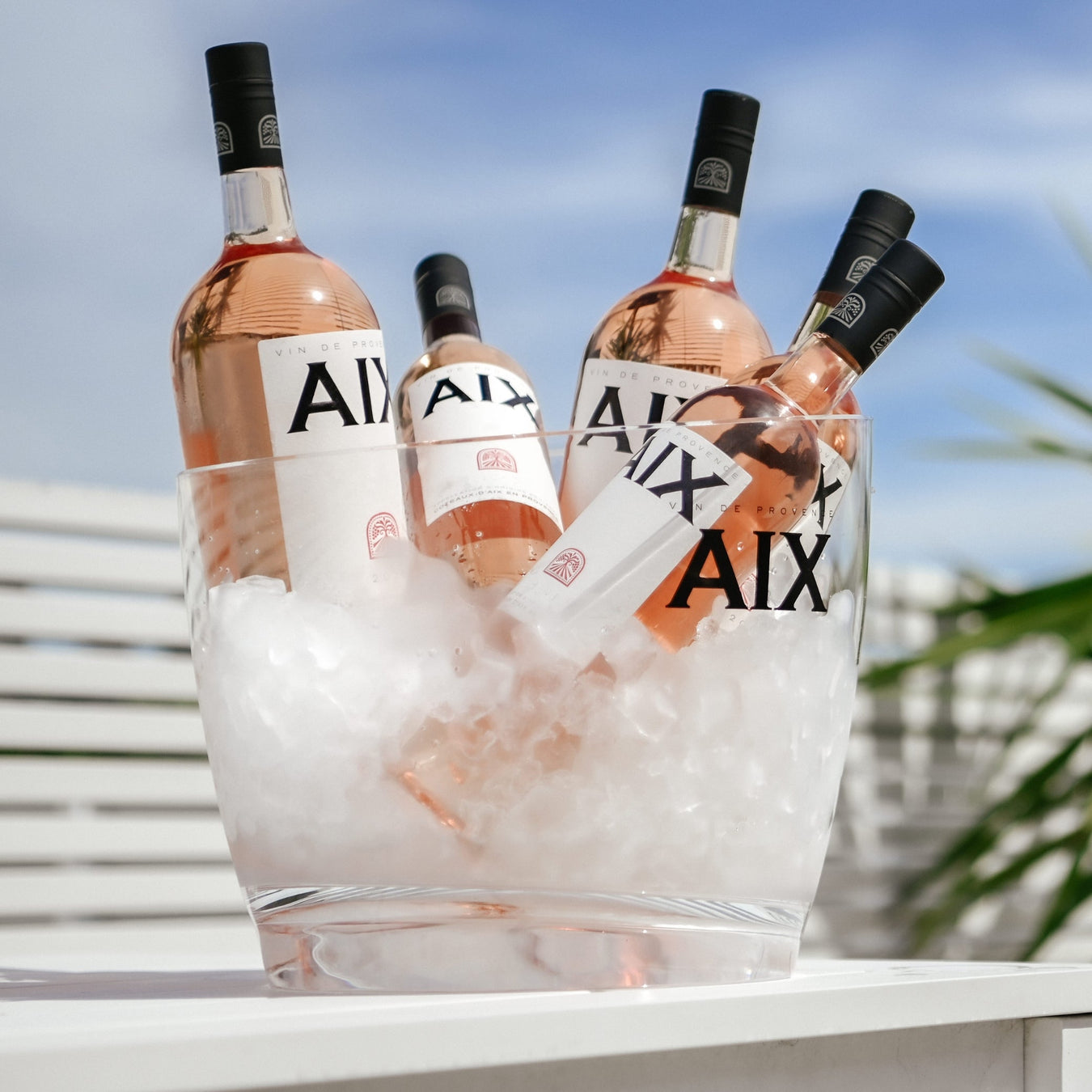 Maison Saint AIX Rosé bottles on ice in a clear bucket outdoors
